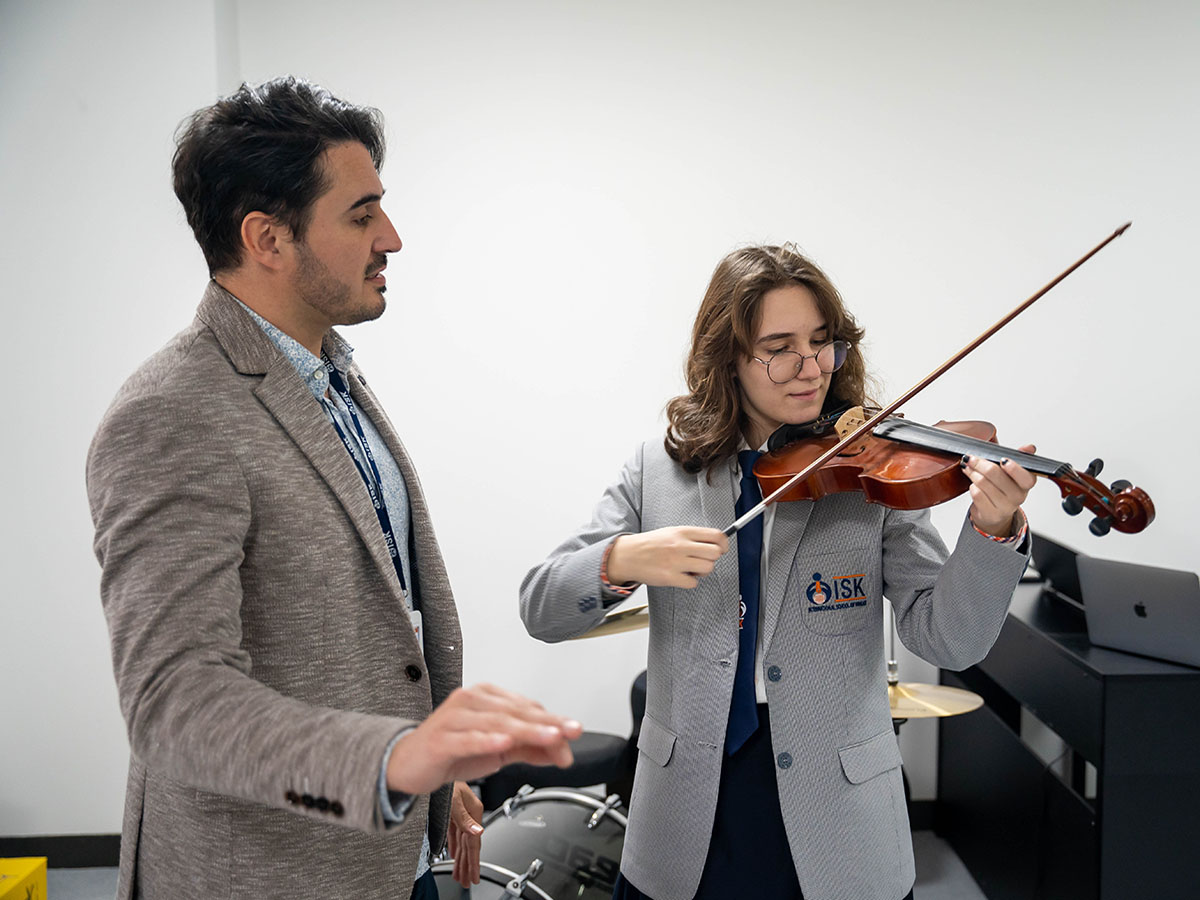 ISK teacher instructing a student playing the violin